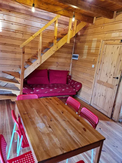 Salon z widokiem na schody, kanape pod schodami oraz stół